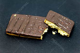 Broken Chocolate Covered Biscuits on Black Background
