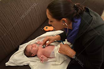 Midwife checks newborn baby heart beat