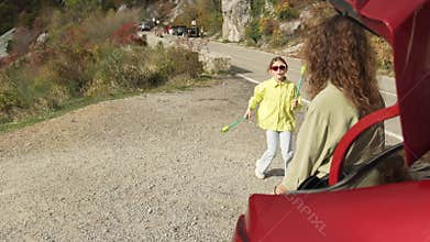 Active Road Trip Break Young Girl Juggling Sticks High Above Mountain View