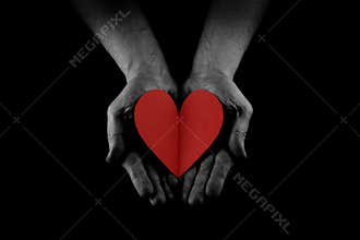 Helping hand concept, Man`s hands palms up holding a Red Heart, giving love, care and support, reaching out