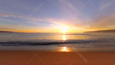 Tropical sunrise on the beach. Waves washing the sand.