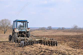 Old tractor with rusty harrow