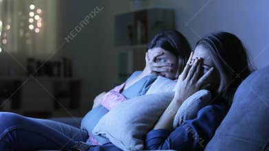 Scared friends watching an horror movie at home