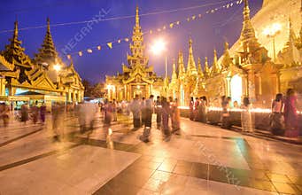 Devotees at Crowded & brightly lit Shwedagon Pagoda in the evening during sunset
