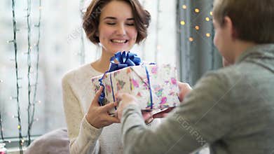 Valentine`s Day concept. A loving couple celebrating Valentine`s Day in the restaurant. Lovers give each other gifts
