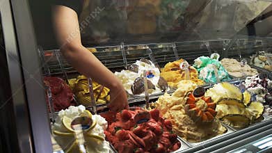 Customer selecting strawberry gelato in a roman gelateria