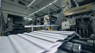 Printing press is releasing folded pages of paper