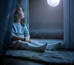 Portrait of a cute little girl looking at the night moon