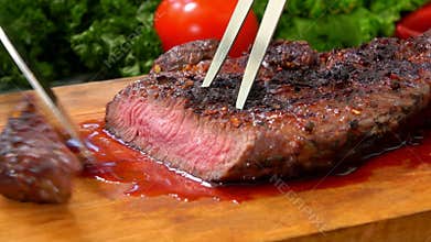 Chef cuts the finished juicy beef steak