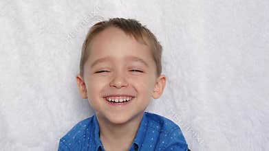Close-up of a cute European appearance boy. Portrait of a happy child. A child laughs looking into the camera.