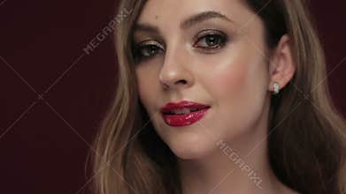 Beautiful brunette model with curls, classic makeup and red lips.