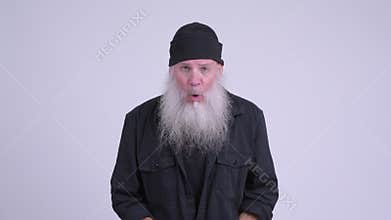 Mature bearded hipster man removing sunglasses and looking shocked