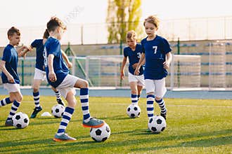 Young Boys of Sports Club on Soccer Football Training. Kids Improving Soccer Skills on Natural Turf Grass Pitch
