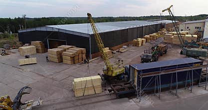Forklift carries a wooden beam, transportation of cargo in the factory. Work process in a woodworking factory