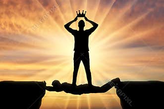 Selfish man puts a crown on his head, he stands on a man in the form of a bridge over a precipice
