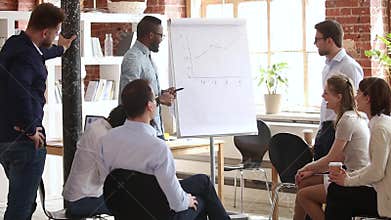 Male african speaker giving flipchart presentation explaining project growth graph
