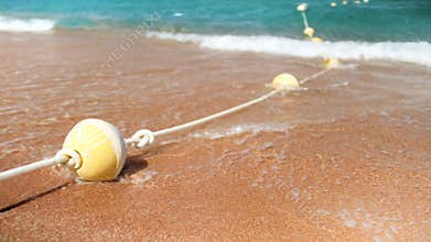 4k slow motion video of blue sea waves breakin on line of buoys at beach