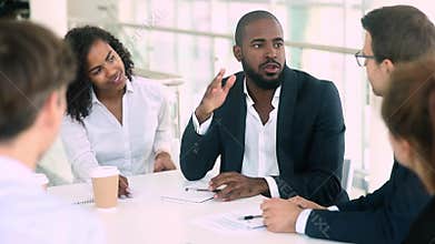 African businessman talking handshaking colleague at group meeting negotiations