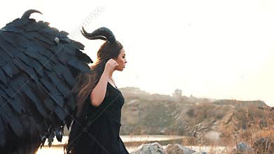 Angel of death and war, girl in black long vintage dress with lace sleeves alone beside large lake, lady with strong