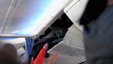 Carry-on baggage. Boarding to airplane with luggage inside cabin