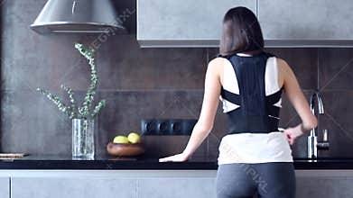 Woman with injured back wears back support bandage