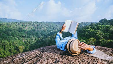 Asian man travel relax in the holiday. sleep relax read books on rocky cliffs. On the moutain summer