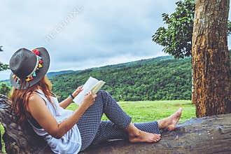 Asian woman travel nature. Travel relax. Study read a book. Nature Education. At public park in summer