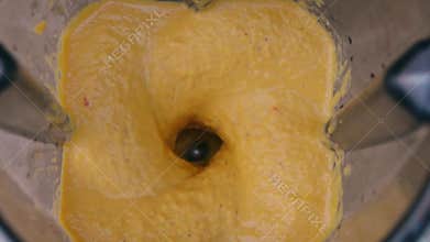 Mixing orange and yellow ingredients in blender. Top view. Preparing vegetable sauce. Vegan and vegeterian food