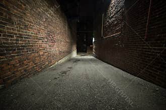 Scary empty dark alley with brick walls.