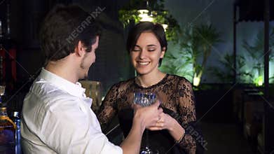 Gorgeous young woman having drinks at the bar with her boyfriend