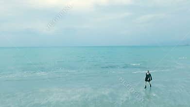 Beautiful woman in depression walks along the beach, cold rainy weather, autumn. girl hipster or punk in black
