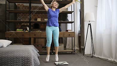 Lovely fit woman celebrating weight loss indoors