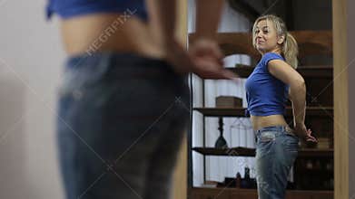 Excited woman in old jeans after losing weight