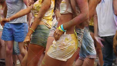 girls in shorts dancing, open air festival, having fun