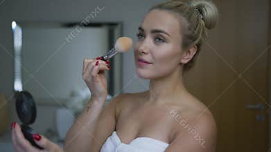 Woman applying powder in morning