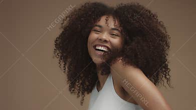Closeup slowmotion portrait of laughin black woman with curly hair