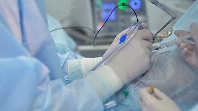 A cataract surgery with the doctor using tools connected to a computer.