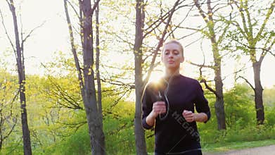 Steadicam slow motion shot: Young woman running in the forest. Healthy Living and Sport