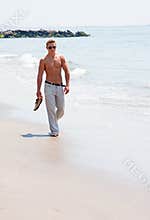 Handsome man walking on beach