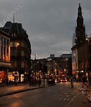Commuters and bus on the street in boar lane in leeds city centre in the evening with illuminated shops
