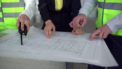 Three architects look over plans together. 4 k close-up Architect working on project. Construction engineering concept