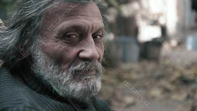 An elderly Afghan man looks at the camera close-up
