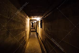 Dark corridor of old underground Soviet military bunker under artillery fortification.