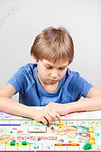 Vilnius, Lithuania - 23 April 2017: Kid playing board game Monopoly