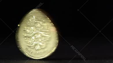 British one pound coin spinning on table