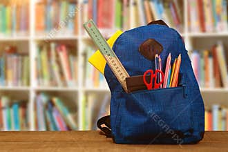Composite image of bag with school supplies on wooden table