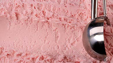 Strawberry ice cream scooped out of container