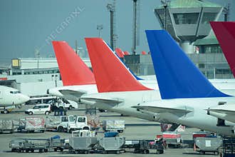Line of parked colorful jet planes. Busy airport.