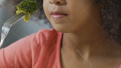 Young girl tries broccoli and hates it, children can't stand raw vegetables