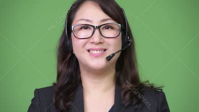 Mature beautiful Asian businesswoman working as call center representative